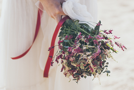 Vista d'un ram o bouquet de núvia inspirat per a un casament a la primavera. Les flors que hi apareixen són diferents tipus de tons de limonium. De colors morats, magentes i blancs barrejats. El ram té un aire silvestre i ferèstec.